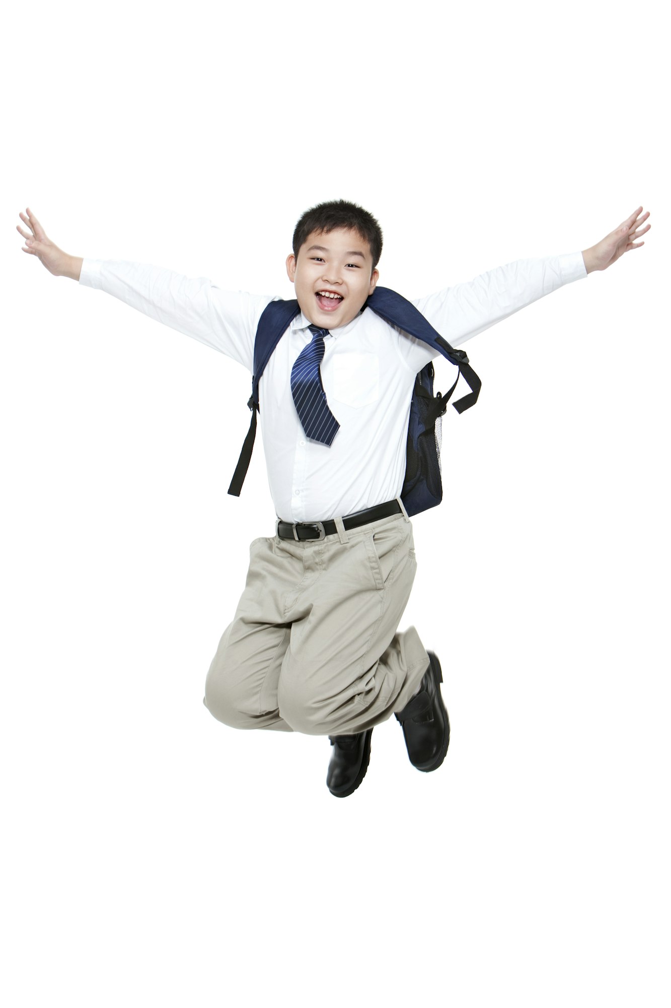 Carefree schoolboy jumping in mid-air with excitement